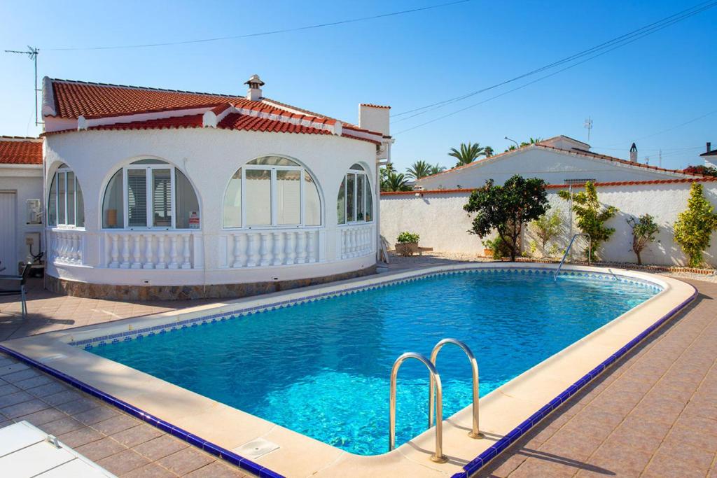 a swimming pool in front of a house at CH Villa Mare Ciudad Quesada in Ciudad Quesada