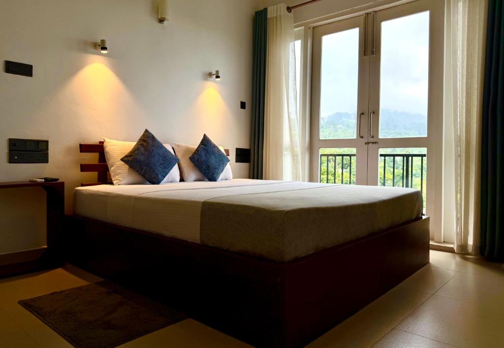 a bedroom with a large bed with a large window at Golden Sky Hotel & Wellness in Kandy