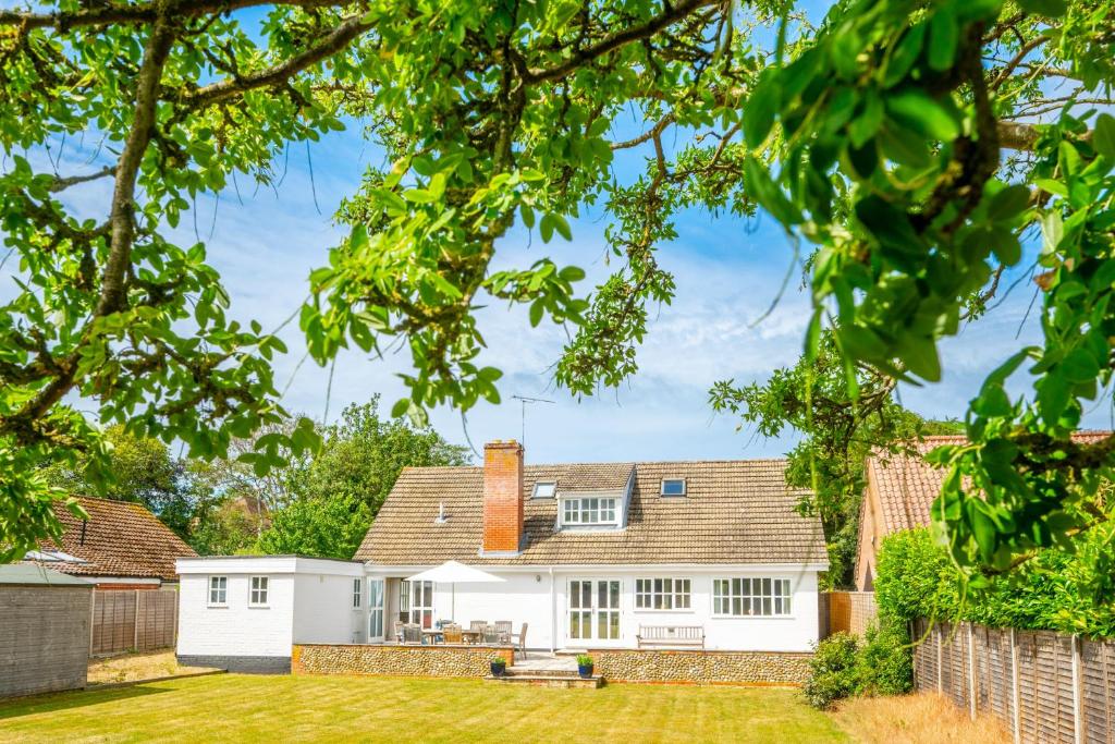 a white house with a fence and a yard at Flint Cottage, Brancaster in Brancaster
