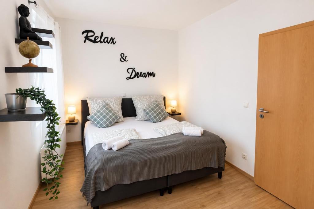 a bedroom with a bed and a sign that reads relax and dream at Comfortable new Apartment in #Koblenz# direkt am Rhein in Koblenz