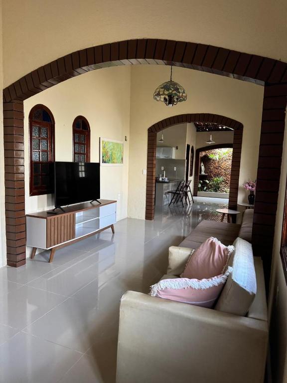 a living room with a couch and a tv at Aconchego da serra no centro de Pacoti in Pacoti