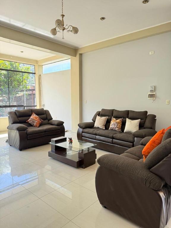 a living room with two couches and a coffee table at 4-Bedroom Apartment in Quillabamba