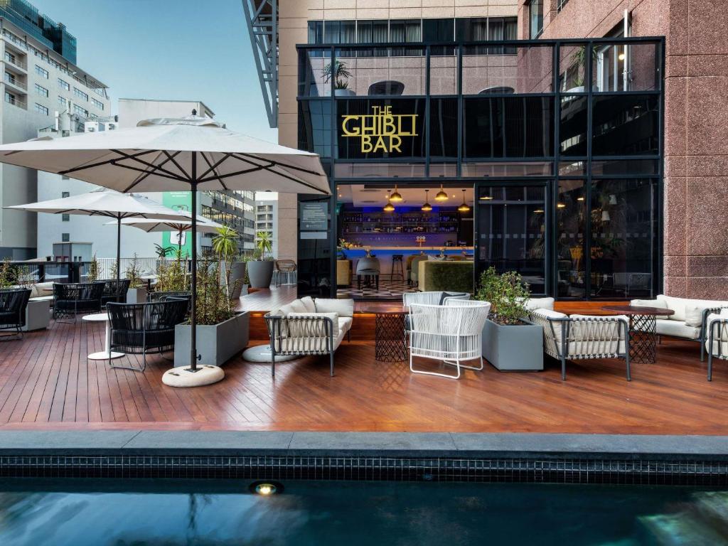 a patio with chairs and tables and a pool at Pullman Cape Town City Centre in Cape Town