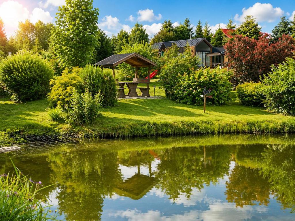a garden with a picnic table and a pond at Leśny Staw Stodoła in Gilwa