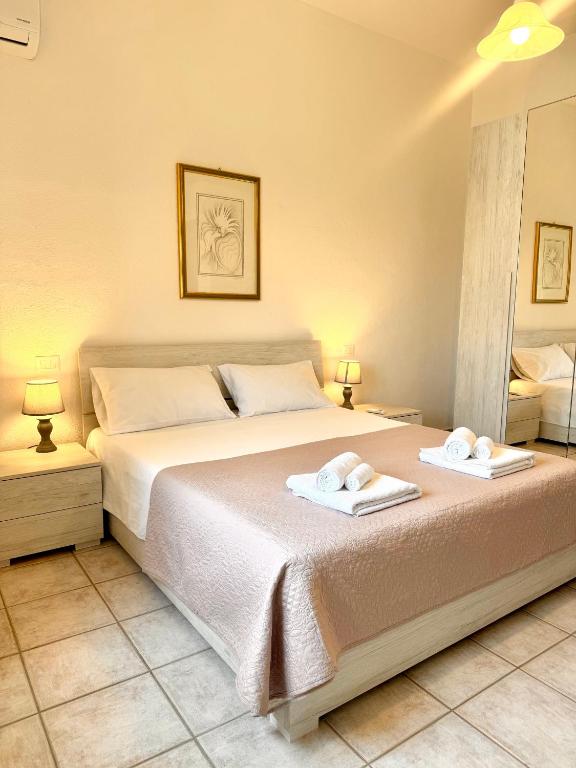 a bedroom with a large bed with towels on it at S'Olivare Posada - Apartment in Posada