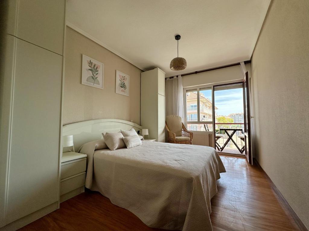 a bedroom with a white bed and a balcony at El Nido de Ris in Noja