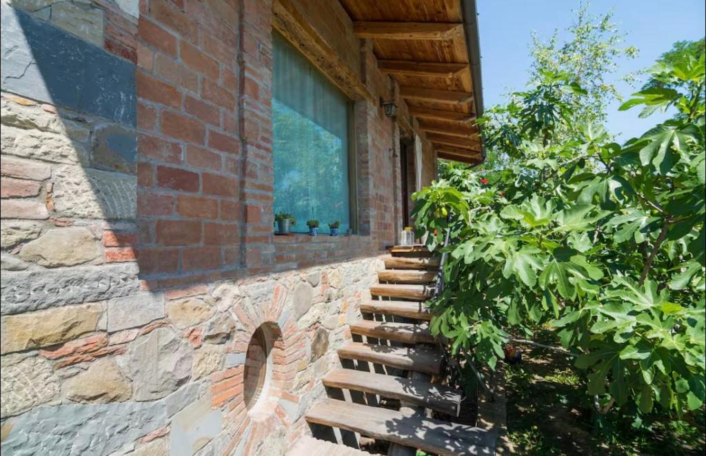 a brick building with a staircase next to a window at Stonehouse LOFT MARTA in Vergato