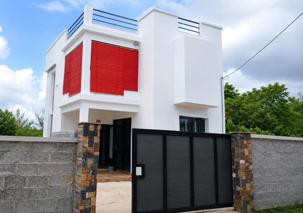 a house with red and white paint on it at Sunrise Bay Villa in Mahébourg