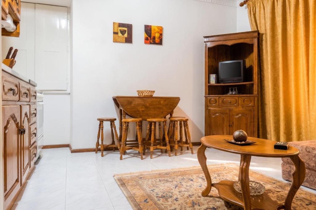 a living room with a table and a tv at Charming Apartment in Alvoco da Serra - Mountain View - 50 sqm in Alvoco da Serra