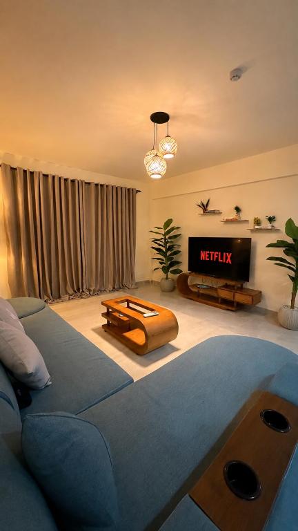 a living room with a couch and a television at 1 BDR Pool Front Cozy Apartment in Port Ghalib