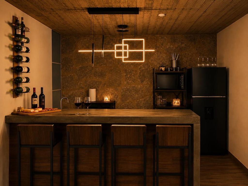 a kitchen with a bar with a microwave and a refrigerator at Cabaña de lujo BlackMoon in Mazamitla
