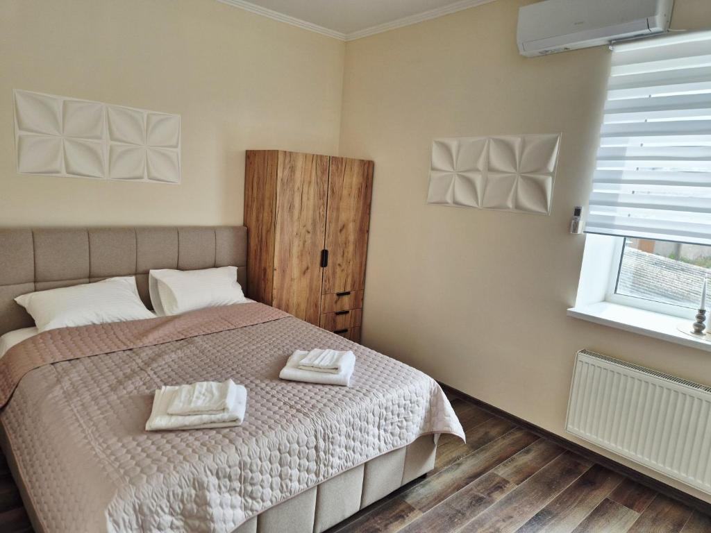 a bedroom with a bed with two towels on it at Zarvantsi Hotel in Khmelëva