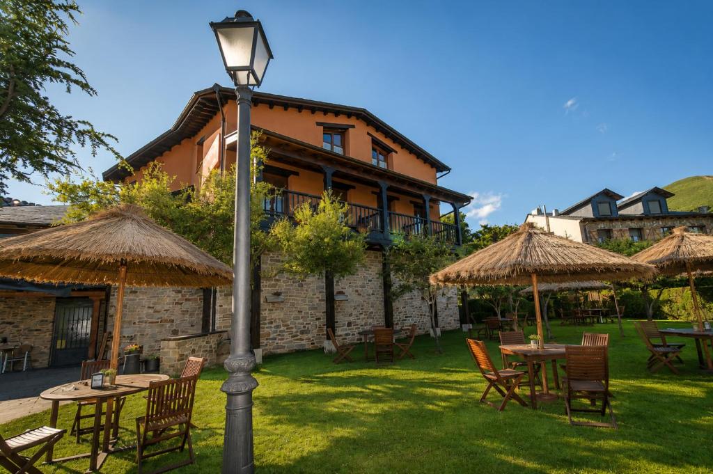 a street light in front of a building with tables and umbrellas at Hotel Rural El Verdenal in Noceda del Bierzo