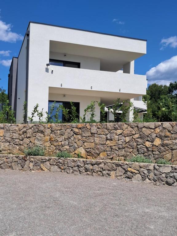 a white house behind a stone wall at Mabora in Crikvenica