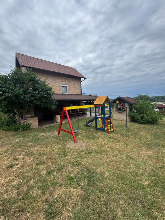 a playground in a yard with a house at Weekendica Aljmaš in Aljmaš
