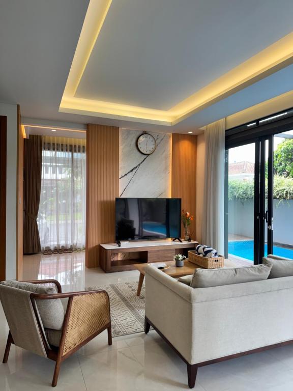 a living room with a couch and a tv at Lioravilla21 Kota Baru Parahyangan in Padalarang
