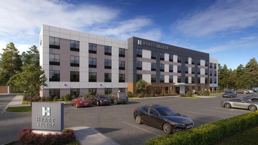 a building with cars parked in a parking lot at Hyatt Select Louisville North in Jeffersonville
