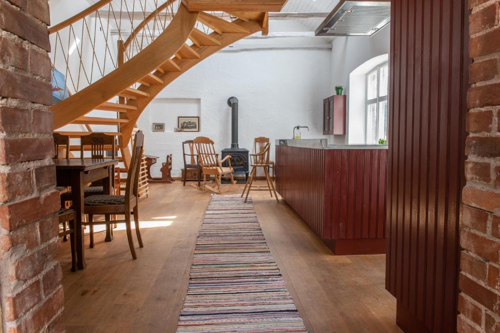 a living room with a staircase and a table and chairs at Villa Vimmerby in Vimmerby