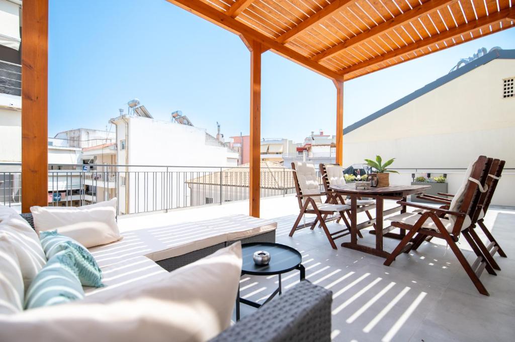 a patio with a couch and a table on a roof at 'Elan Suites in Preveza