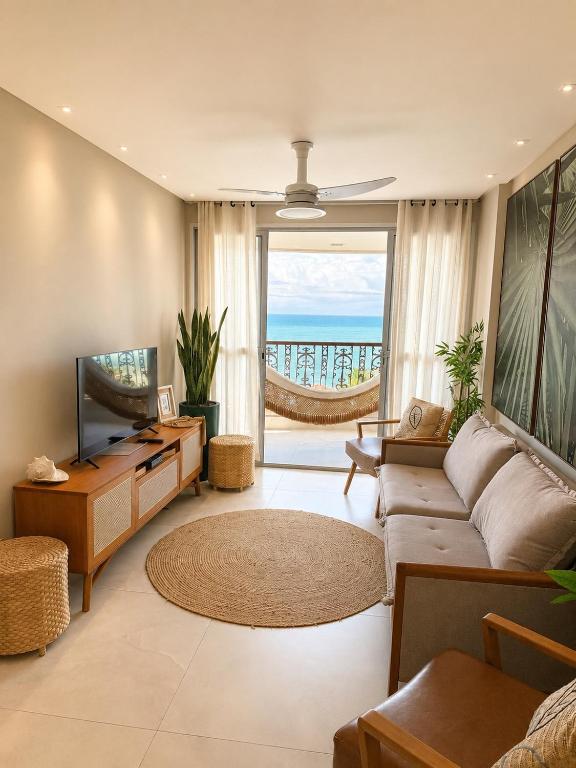 a living room with a couch and a television at Ap centro de Guarapari com as melhores vistas!!! in Guarapari