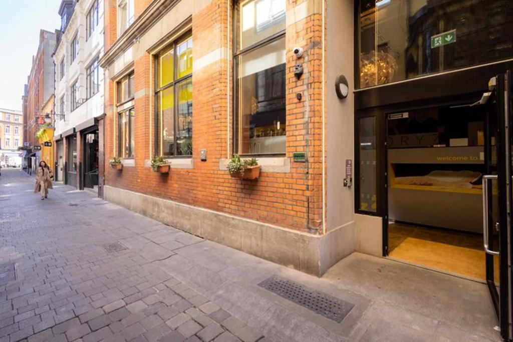 a person walking down a street next to a brick building at Garner Hotel Dublin Temple Bar by IHG in Dublin
