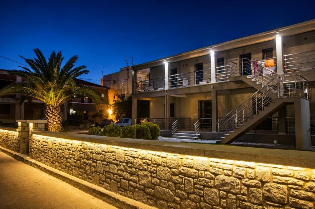 a building with a stone wall at night at Studio vasiliki in Myrina