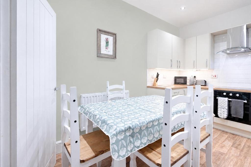 a white kitchen with a bunk bed in a room at Spacious 4BR Home with Garden, Swansea in Swansea