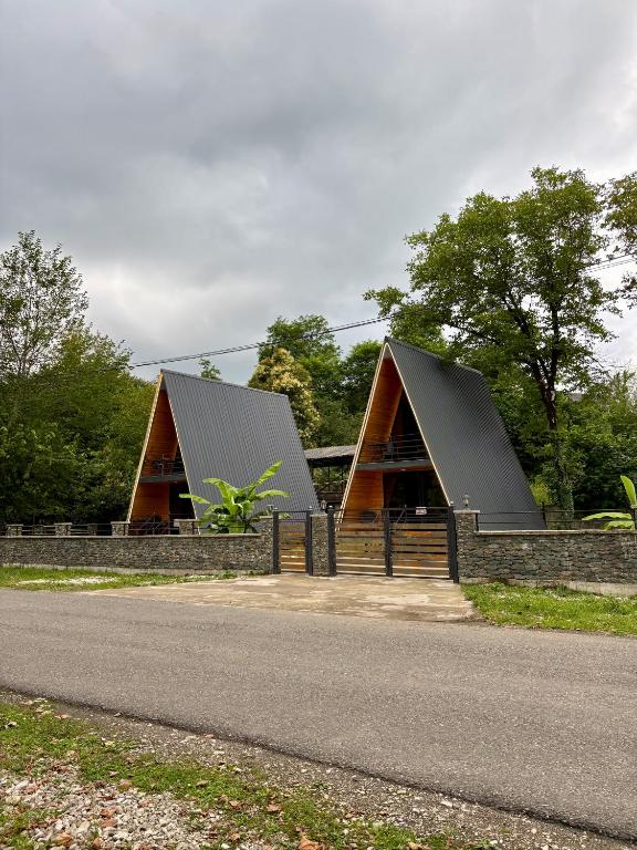 a house with two roofs on the side of a road at Wooden House Martvili in Martvili