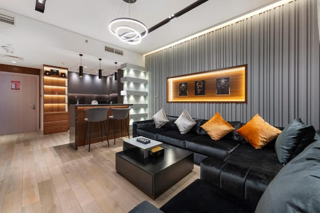 a living room with a black couch and a bar at Yas Island Luxury Apartment by City homes in Yas Island
