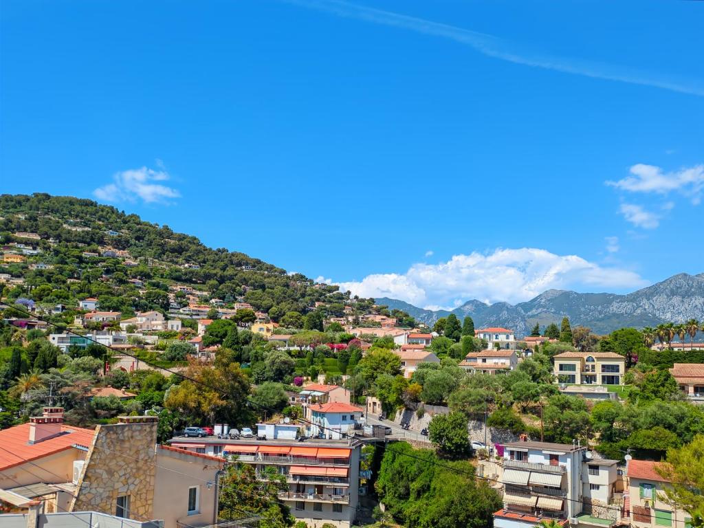 a town on a hill with houses and trees at Mermaid Beach in Roquebrune-Cap-Martin