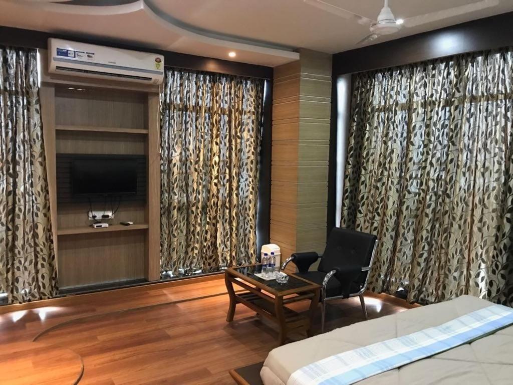 a bedroom with a bed and a table and a chair at Hotel Haven Intercontinental in Agartala