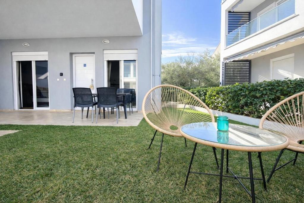 a patio with two chairs and a table in a yard at Eliza Meraki in Ofrínion