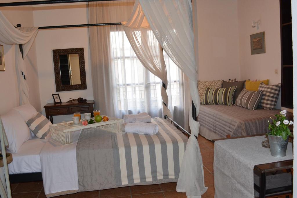 uma sala de estar com duas camas e um sofá em Loggia Traditional Suites em Rethymno Town
