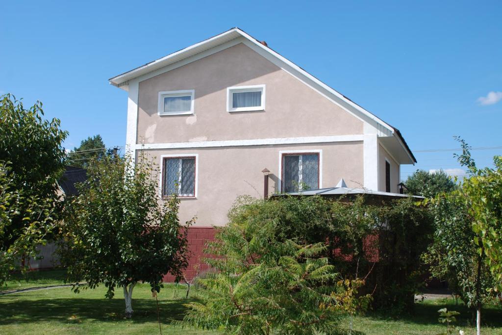 a pink house with trees in front of it at Дім дача біля води in Protsev