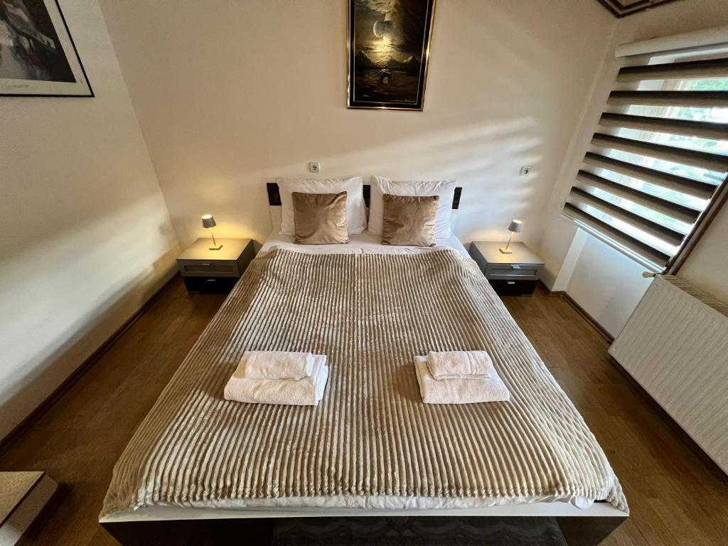 a bedroom with a large bed with two towels on it at Vlašić Moon Apartments in Vlasic