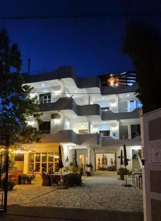a large white building with a courtyard at night at Hostel Calao in Shkodër