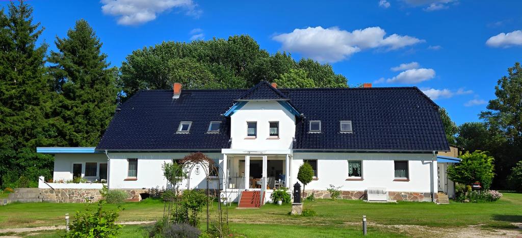 a white house with a blue roof at Villa Wiese Störtebecker in Katzow