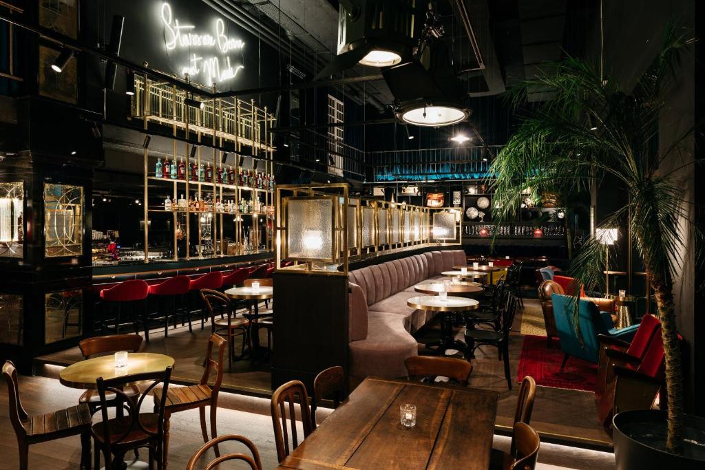ein Restaurant mit Tischen und Stühlen und einer Bar in der Unterkunft Ruby Mimi Hotel Zurich by IHG in Zürich