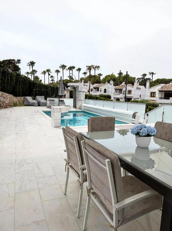 a patio with a table and chairs and a pool at Villa Capitan in Orihuela Costa