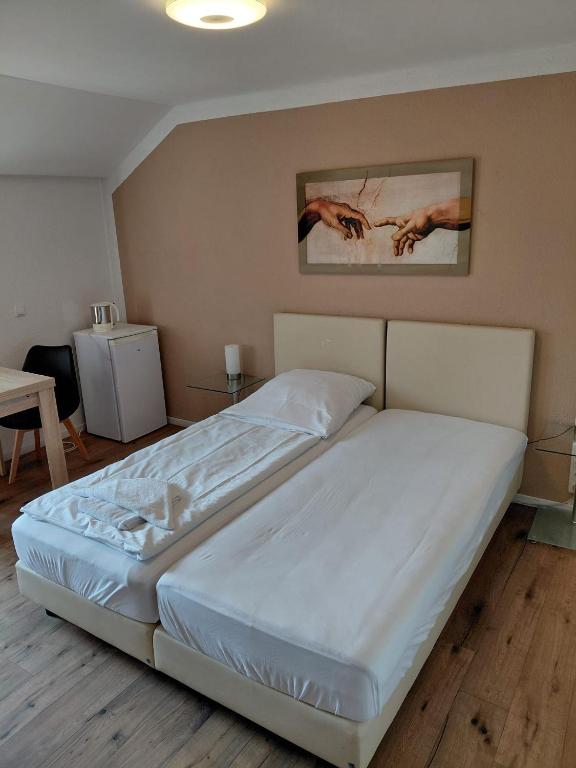 a bedroom with a large white bed in a room at Pension Hofmann in Gröbenzell