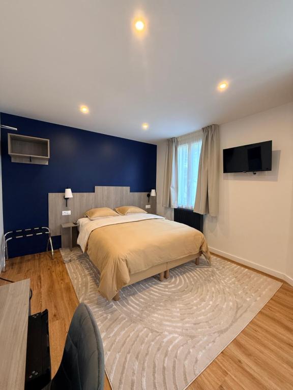a bedroom with a large bed and a blue wall at Laulique in Les Lilas