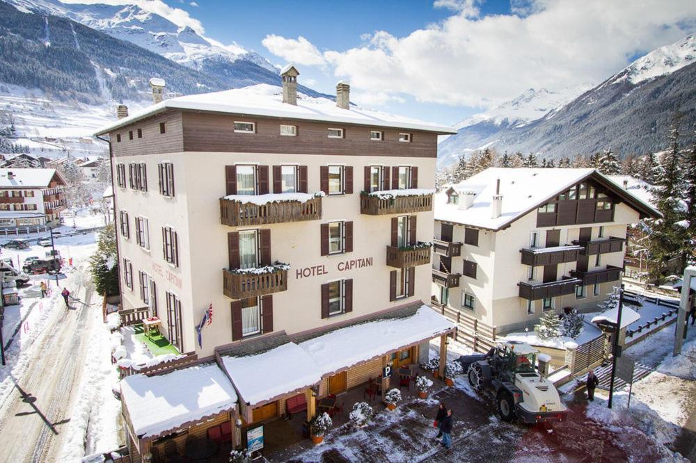 an aerial view of a hotel with snow covered mountains at Hotel Capitani in Bormio