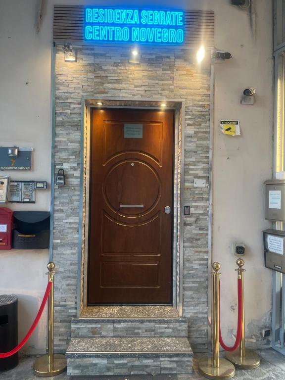 a brown door in a brick wall with a sign above it at Residenza Segrate Centro Novegro near LINATE Airport in Segrate