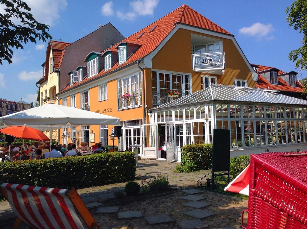 a large building with a table and chairs in front of it at Altes Kasino Hotel am See in Neuruppin