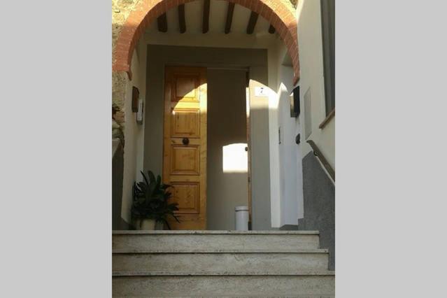an entrance to a house with a wooden door and stairs at Casa Michelangelo in Megognano