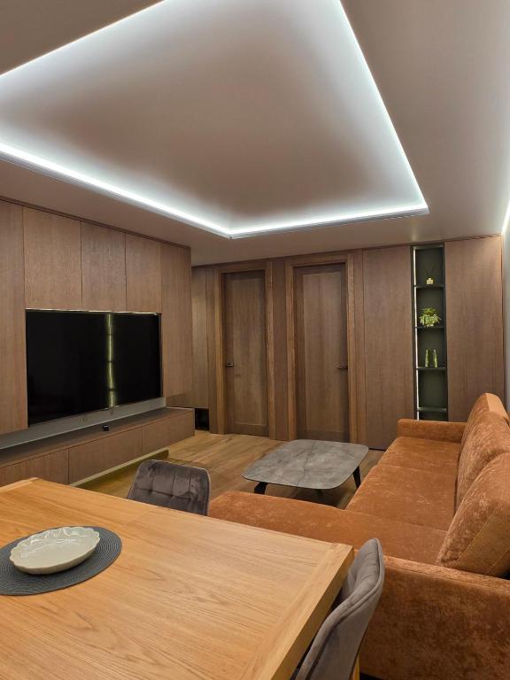 a living room with a table and a television at Central Apartament in Telšiai