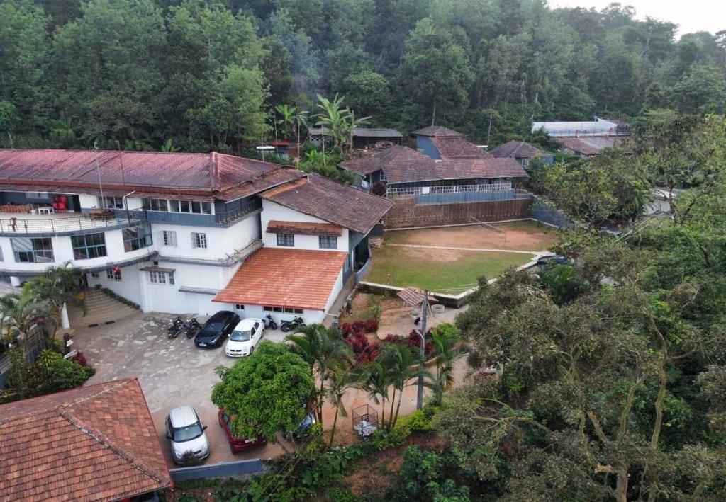 an aerial view of a house with cars parked in front at The Lantana Resorts in Madikeri