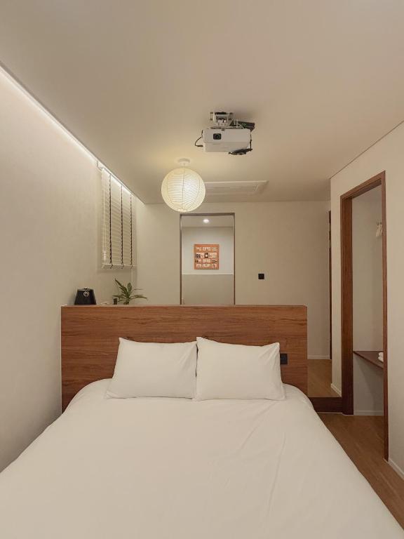 a bedroom with a large white bed with white pillows at 무무 mumu in Seoul