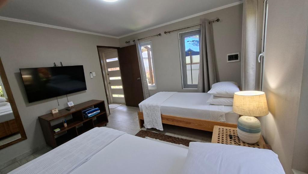 a hotel room with two beds and a television at SEMEREL APARTMENT in Palm-Eagle Beach