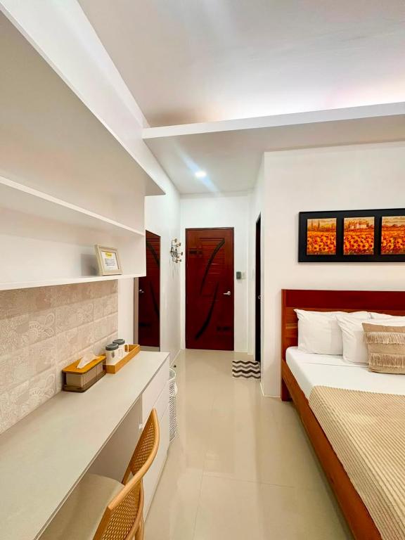 a bedroom with a large bed and a red door at Ramz Residence in El Nido